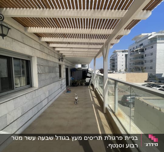 מרפסת עם פרגולה מעץ ובניינים ברקע